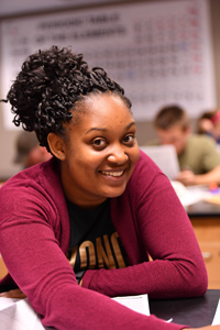 Girl smiling at a desk in class